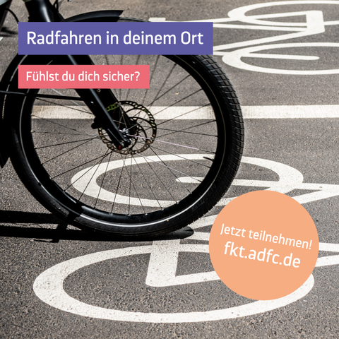Vorderrad eines Fahrrads auf einem Radweg mit Fahrradpictogrammen