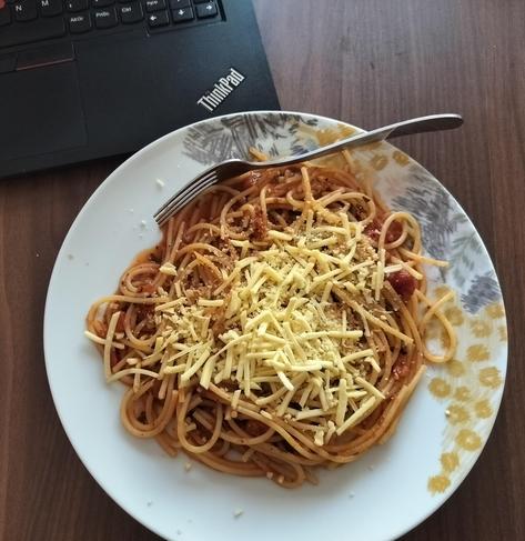 Plate of pasta with a Lenovo ThinkPad to the top of the plate