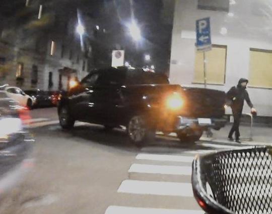 L'immagine mostra un pick-up nero parcheggiato all'angolo di un incrocio, posizionato in modo da ostruire le strisce pedonali in due direzioni., attraversando le strisce pedonali.