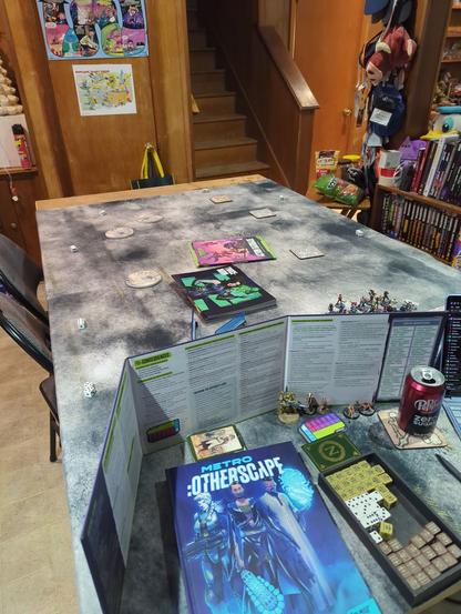 A game table set up for a game of Metro: Otherscape. Dice, toy soldiers and the GMs cave.
