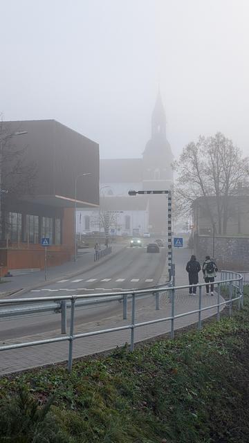 Valmieras iela ar teātra ēku un baznīcu miglā.