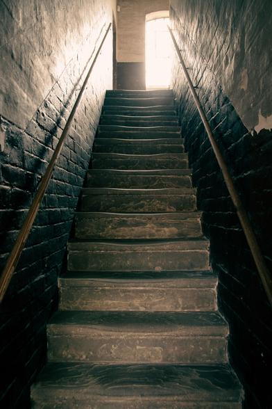 A staircase viewed from below.  A bright window at the top.