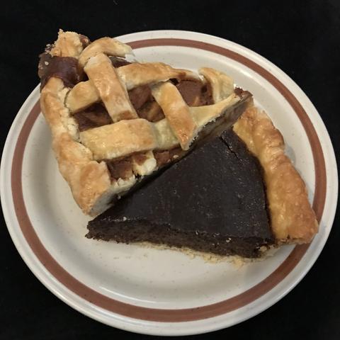 A dessert plate barely containing two large slices of pie, the upper a lattice-topped caramel apple, the lower a dark custard-type (you can't tell at all from this picture but it's honey walnut raspberry poppyseed).