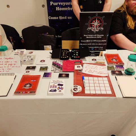 stall with PENANCE RPG leaflets, sign up sheet and cards