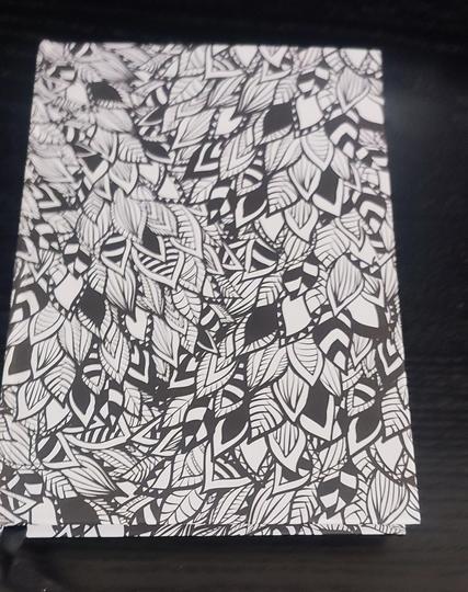 a book  with a pattern of black and white leaves cover.