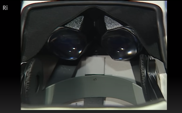 imagem do interior de um capacete de realidade virtual antigo (1991): duas lentes e um headset pretos.