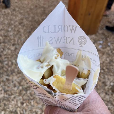 Eine Tüte Pommes Frites mit Mayonnaise.