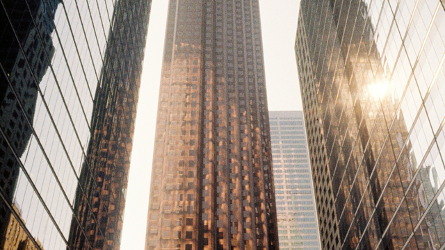 Tall office towers reflect each other in the morning light, they look more like abstract forms than places for humans.