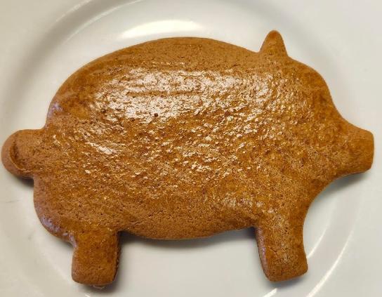 A shiny golden brown Marranito rests on a white plate.