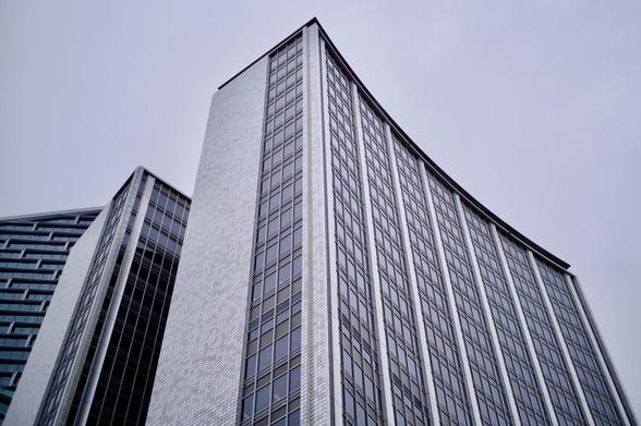 Photograph looking up at the old AMP building in Sydney.  The building is two towers of steel, glass and white/grey tiles.