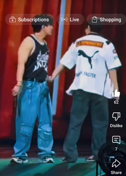 Changbin and Seungmin on stage during a concert. Changbin has just grabbed Seungmin's wrist, and is in the middle of twisting his arm and pulling him in