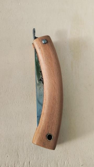 Le couteau fermé, sur une planche claire.