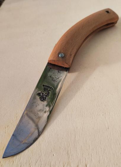 Le couteau, sur une planche, vu pointe vers le bas.