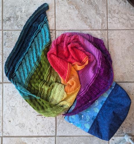Crown Wools wrap: a bias-knit parallelogram-shaped wrap done with 12 different rainbow colours of yarn in different stitch patterns.