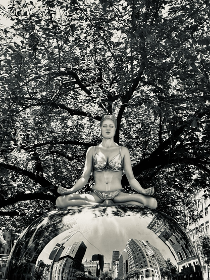 Black-and-white photo of a realistic sculpture of a swimmer and a bathing cap and bikini sitting on a large silver orb that reflects buildings in NYC with trees in the background