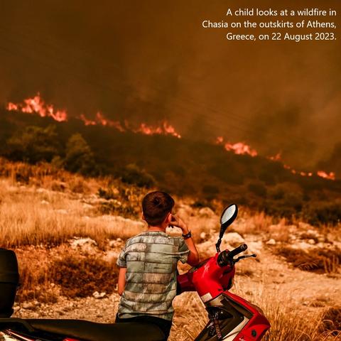 photo - A child looks at a wildfire in Chasia on the outskirts of Athens, Greece, on 22 August 2023.