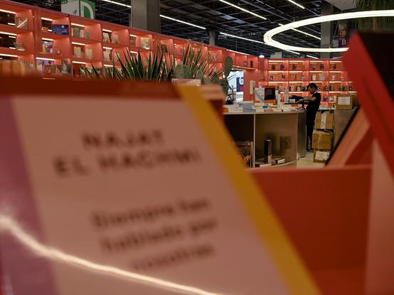 Un librero trabaja tras el mostrador del enorme stand de España en la FIL Guadalajara.