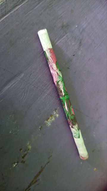 Lápiz verde con rosa aún fresco y sin cortar las puntas sobrantes.