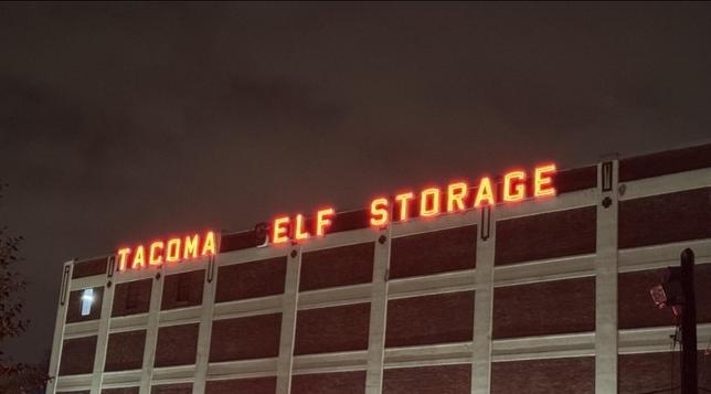 Photo of a building at nighttime. Along the top, the words "Tacoma Elf Storage" are lit in bright neon letters. Closer examination shows that it actually reads "Tacoma Self Storage," but the S in Self has burned out.