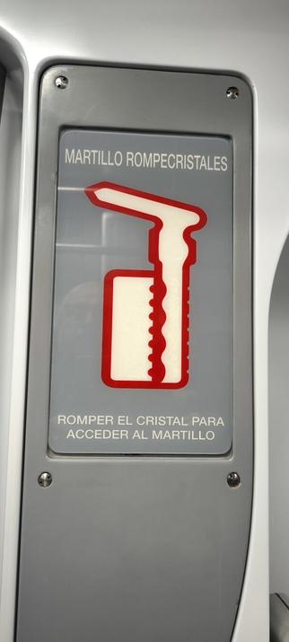 Un cartel en el tren de cercanías con un bucle lógico imposible: para obtener el martillo rompecristales has de romper el cristal que lo oculta.