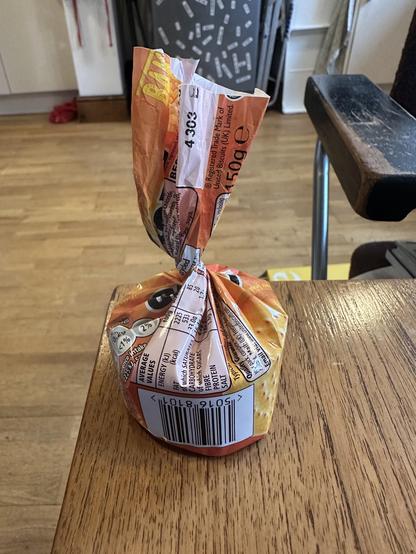 The last few biscuits in a packet of Cheddars. The wrapper has been twisted round to keep them fresh.