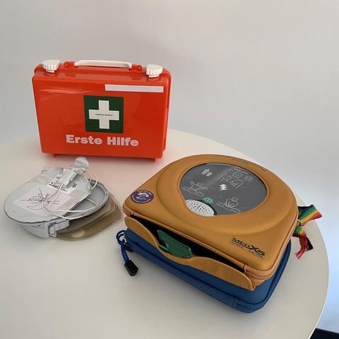 Nahaufnahme eines Ersteh Hilfe Kastens und einem Defibrilator