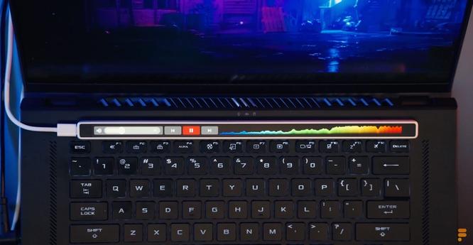 Die illuminierte Flexbar liegt mit einem USB-C-Kabel angeschlossen oberhalb der Tastatur eines Laptops. Foto: (c) ENIAC.