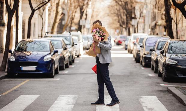 Hombre con un ramo de flores por en medio de la calle (Gajic)