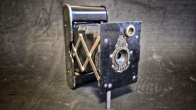 The Kodak Vest Pocket camera, Autographic version, on a black background.
