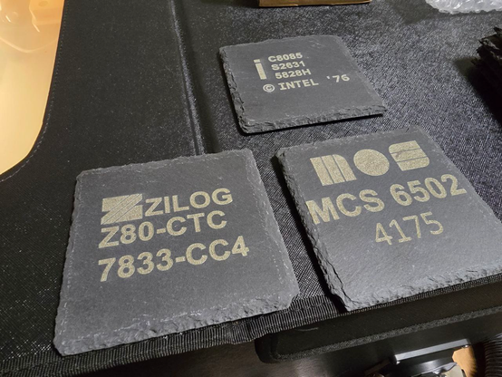 Laser engraved slate coasters showing markings of a 8085, a Z80 and a 6502