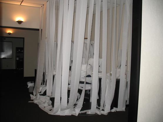 Office desk covered in toilet paper (clean).