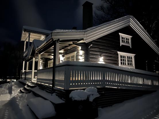 Photo of Skihytta, an event space in Tromsø, at night. The building is well-lit, giving it a glowing appearance.