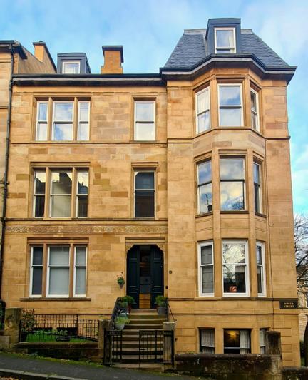 A three storey blonde samdstone residential building with a basement and an attic.