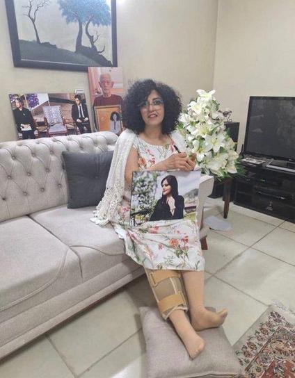 Narges Mohammadi, holding a photograph of Mahsa Amini, at home after her release from Evin Prison in Tehran, Iran