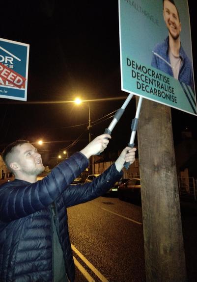A photo of Killian cutting down a poster.