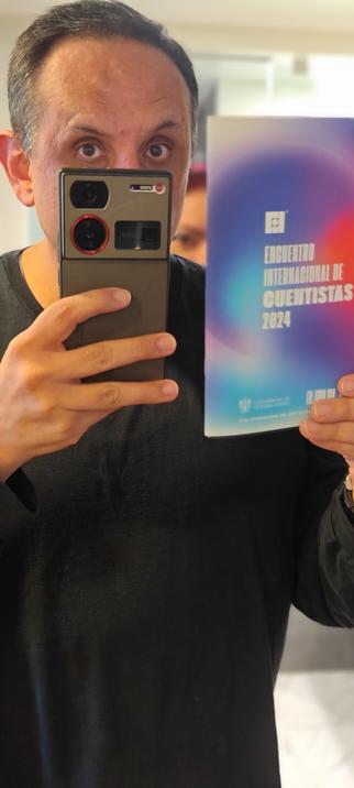 Un hombre sostiene un ejemplar de la antología impresa del Encuentro Internacional de Cuentistas de la FIL Guadalajara.