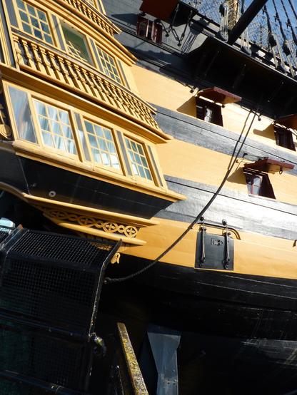 stern of a Napoleonic era warship, with the windows of the captain's cabin showing architectural modelling and grace