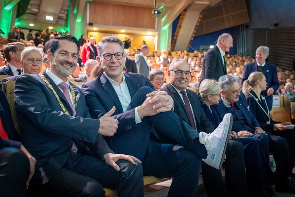 TUM's President Thomas F. Hofmann and Bavaria's Minister of Science Markus Blume who proudly presents his white sneakers with TUM branding, sitting in the first row of the TUM Audimax.