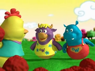 The foreground shows three animated characters: a yellow chicken, a purple cow, and a blue hippo. They appear to be in a playful interaction, possibly a scene from a children's show. The background is a bright, sunny field with cartoonish trees and clouds, suggesting a whimsical, child-friendly setting. The overall aesthetic is vibrant and playful, designed to appeal to young children.

The characters seem cheerful and friendly; they are cartoon animals and don't have human-like emotions or characteristics. Their size suggests they are targeted toward a young audience. It's impossible to determine their age, race, or socio-economic status as they are not based on any particular human identity. The scene seems to be from an animated children's show and likely created using 3D animation software. The image doesn't provide information about the camera or creation time.

The purple cow's shirt has a small 'W' on it, a detail easily missed. The chicken seems to be holding or interacting with a red, round object. The style of animation is simplistic but effective at conveying a sense of fun and friendliness. The lack of sharp shadows and the bright, even lighting are characteristic of animation created for young viewers.

Alt text by They See Your Photos