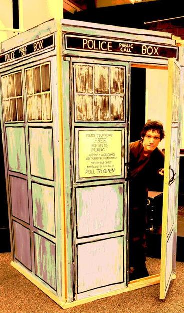 Posterized photo of Doctor Who (actor) looking out of his Police Box (Tardis).