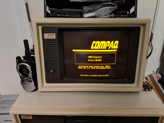 My Compaq Desktop Model 1, with Compaq's original diagnostic screen (large, right-justified Compaq logo in capped italics, version number (8.00 DP256), copyright, and a "press enter to continue" prompt, all in CGA, showing on an amber monitor.