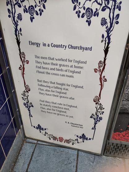 A panel with a flowery border. The poem inside reads:

The men that worked for England
They have their graves at home:
And bees and birds of England
About the cross can roam.

But they that fought for England,
Following a falling star,
Alas, alas for England
They have their graves afar.

And they that rule in England,
In stately conclave met,
Alas, alas for England,
They have no graves as yet.

G. K. Chesterton
Published 1922