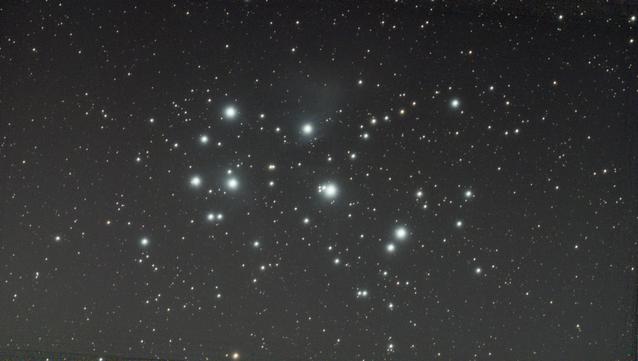Pleiades shining bright white blue, with a bit of nebula showing.