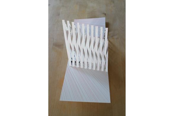 Carte kirigami pop up illustrée de lignes rouges et traces noires