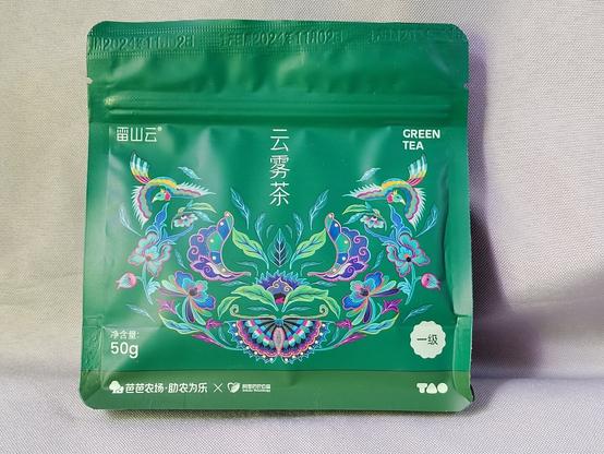 This is the bag (photo from the original "queued tea" post).  It's a green satchel holding 50g of tea with a lovely Miao design of flowers and birds on the outside.  The Ali philanthropic group did a wonderful job of selling this tea with just the packaging!