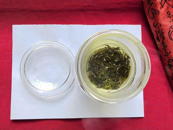 The production quality continues to show itself in the wash.  The leaves unfurl quickly, but do not lose their differentiation: the tippy leaves still look light, the main body leaves still look dark.

But here was the first sign that this tea is perhaps not best-suited to a delicate green like a Cloud and Mist.  Literally every Cloud and Mist tea I've ever had: Lushan, Dog Brain, Emeishan, etc. etc. etc. gets a very powerful astringent aroma mixed with a very strong, sweet grasslike one.  This has almost no bouquet.  What it had was the faint presence of the sweet grass scent, but not very much of it.

Needless to say I didn't wash it for long, dumping it within seconds of taking the photo (and having had the phone readied for taking the photo before the first drop of water touched it).