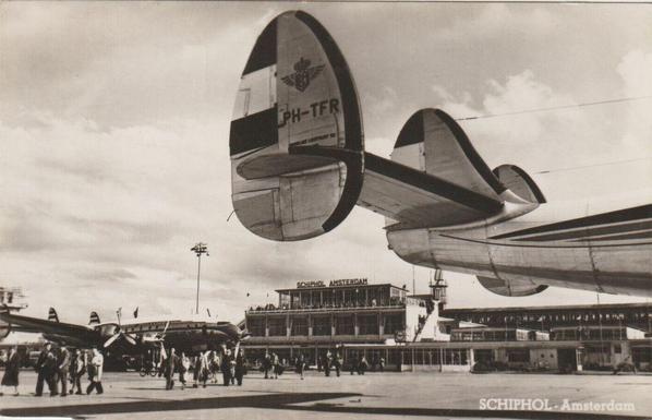 One plane is in the background, close to the terminal. In the front of the viewer is a tail from another plane.