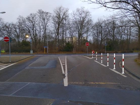 Kreuzung Südring-Albert-Stohr-Straße. Ein freilaufender Rechtsabbieger ist in einer Fotomontage mit Pollern abgesperrt. Im Hintergrund ist eine quer verlaufende, rot markierte Radfurt zu sehen.