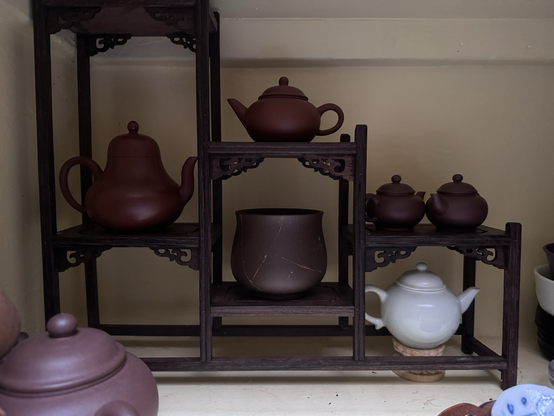 A Chinese display shelf with teapots.
