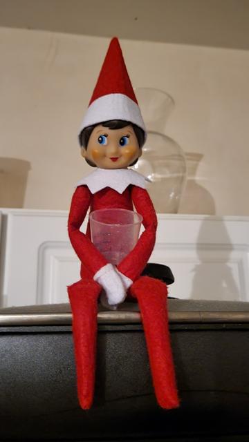 Elf on the shelf with an empty cup of treats